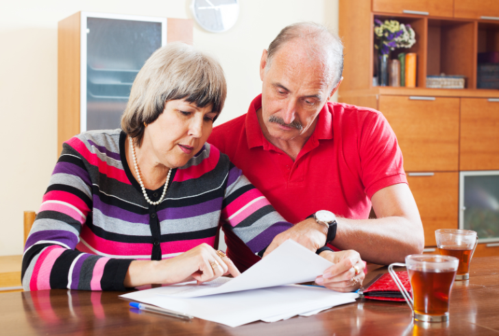 Elderly couple reviewing financial documents