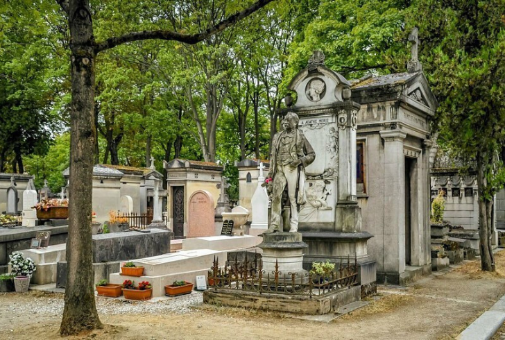 Restored Paris gravestone surrounded by flowers & tress